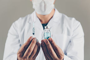 Docteur tenant un vaccin et une seringue
