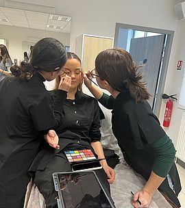 Photo de jeunes femmes maquillant une autre jeune femme - Agrandir l'image (fenêtre modale)